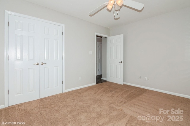 unfurnished bedroom with a closet, carpet, a ceiling fan, and baseboards