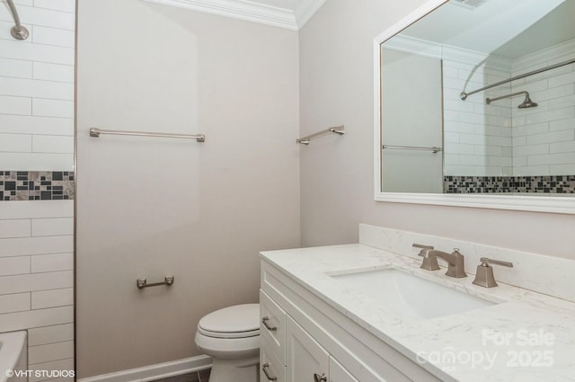 bathroom with toilet, baseboards, crown molding, and vanity