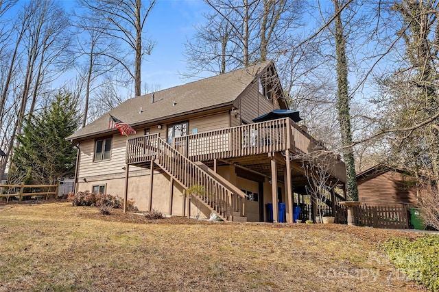 back of property featuring a deck and a lawn