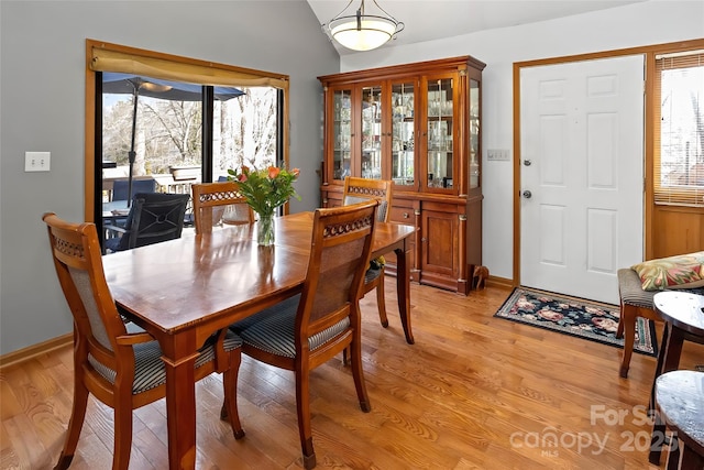 dining room featuring lofted ceiling and light hardwood / wood-style floors