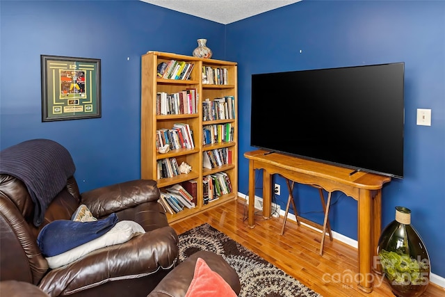 living room featuring wood-type flooring and a textured ceiling