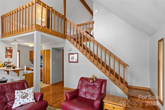 living room with high vaulted ceiling and light hardwood / wood-style floors