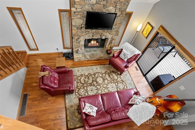 living room featuring hardwood / wood-style flooring and a stone fireplace