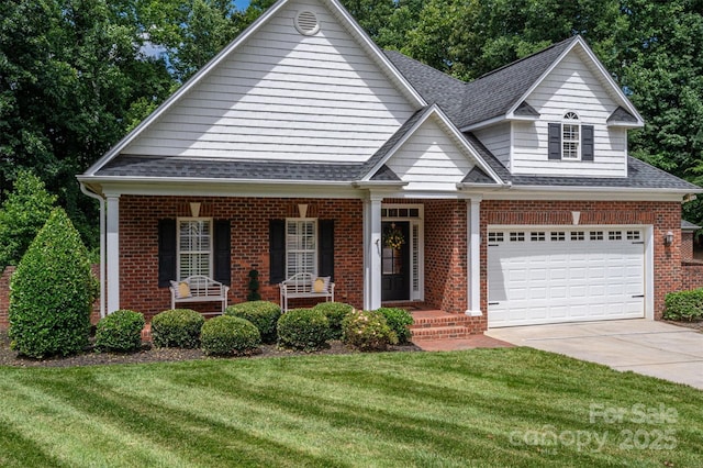 view of front of property with a garage, a front yard, and covered porch