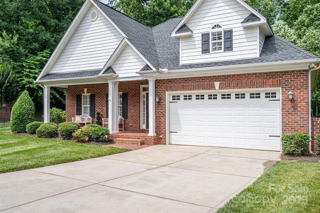 view of front of house featuring a garage, a front yard, and covered porch