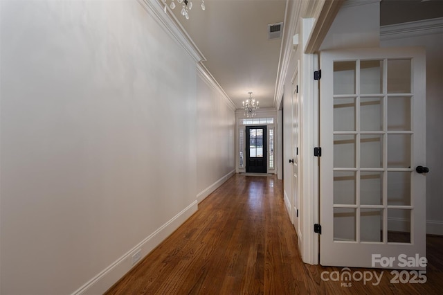 hall with a notable chandelier, crown molding, and dark hardwood / wood-style floors