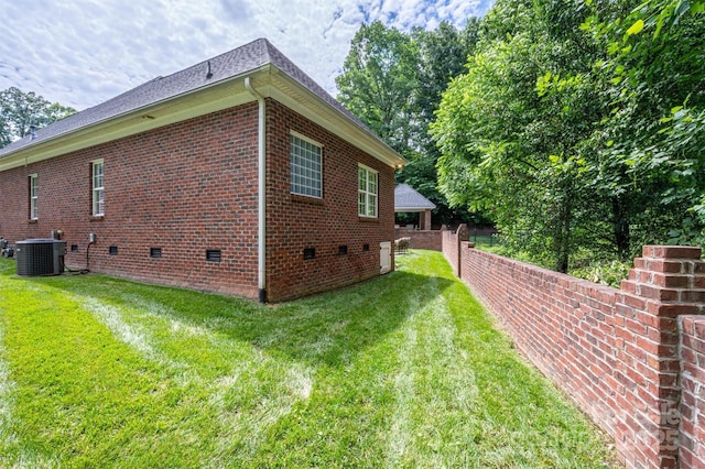 view of side of home with central AC unit, a gazebo, and a lawn