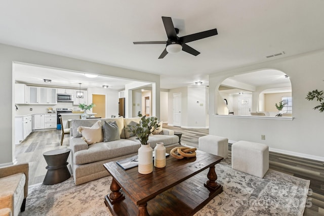 living room featuring light hardwood / wood-style flooring and ceiling fan