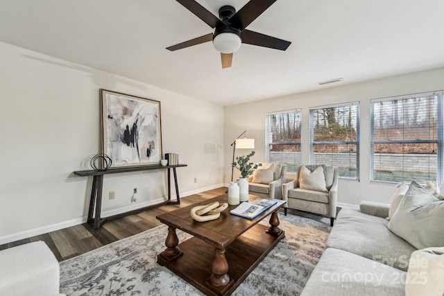 living room with dark wood-type flooring and ceiling fan