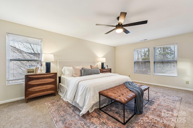 carpeted bedroom featuring multiple windows and ceiling fan