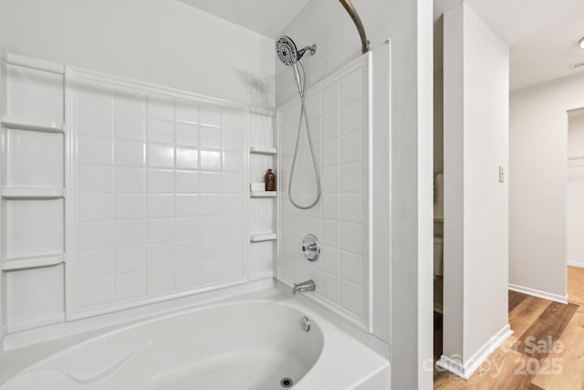 bathroom with hardwood / wood-style floors and tiled shower / bath combo