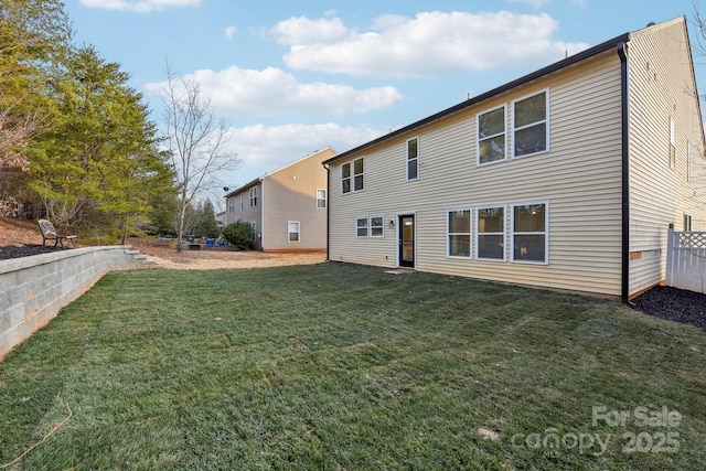 rear view of property featuring a lawn