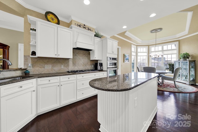 kitchen with white cabinetry, sink, backsplash, and dark stone counters