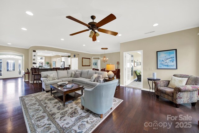 living room featuring dark hardwood / wood-style floors and ceiling fan with notable chandelier