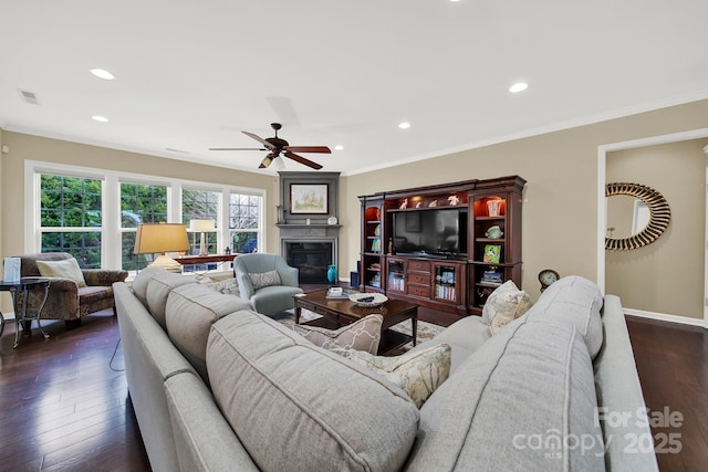 living room with dark wood-type flooring, ceiling fan, and ornamental molding