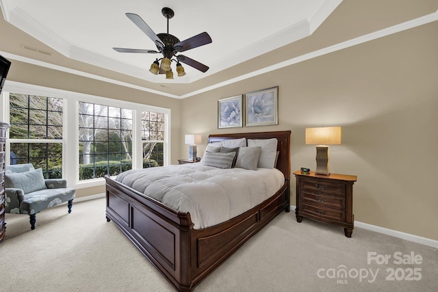 bedroom with a raised ceiling, ornamental molding, light carpet, and ceiling fan