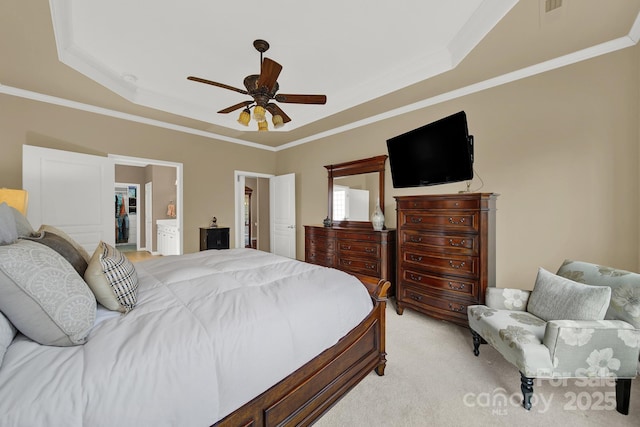 bedroom featuring a spacious closet, a raised ceiling, ceiling fan, and ensuite bathroom