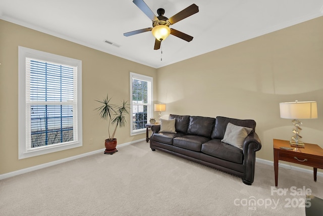 living room featuring light carpet, plenty of natural light, ornamental molding, and ceiling fan