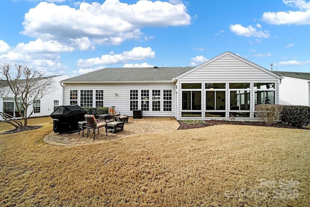 rear view of property with a yard and a patio area