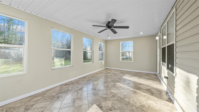 unfurnished sunroom featuring ceiling fan