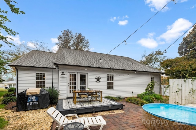 back of house featuring a pool side deck, a patio area, and french doors