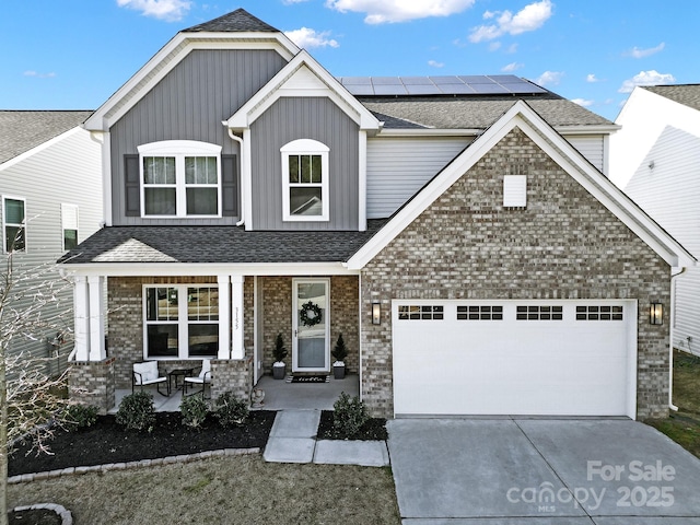 view of front of home featuring covered porch, solar panels, and a garage