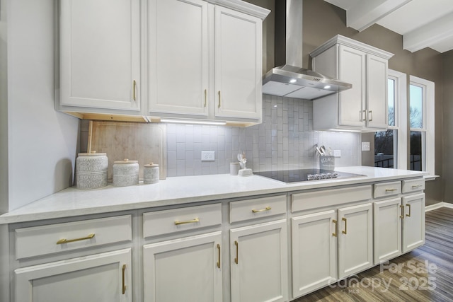 kitchen with tasteful backsplash, wall chimney exhaust hood, black electric stovetop, white cabinets, and dark hardwood / wood-style flooring