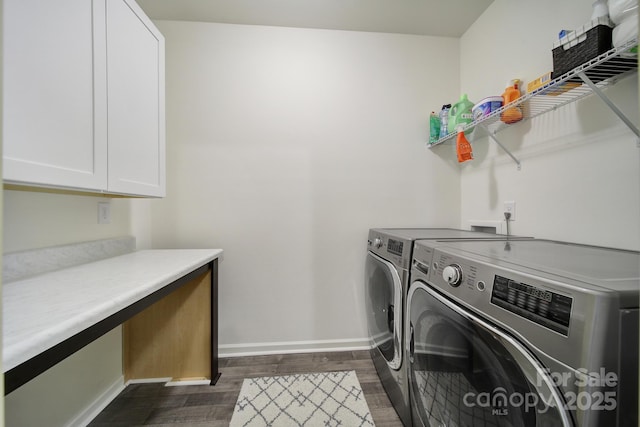 laundry room featuring cabinets, washing machine and clothes dryer, and dark hardwood / wood-style flooring