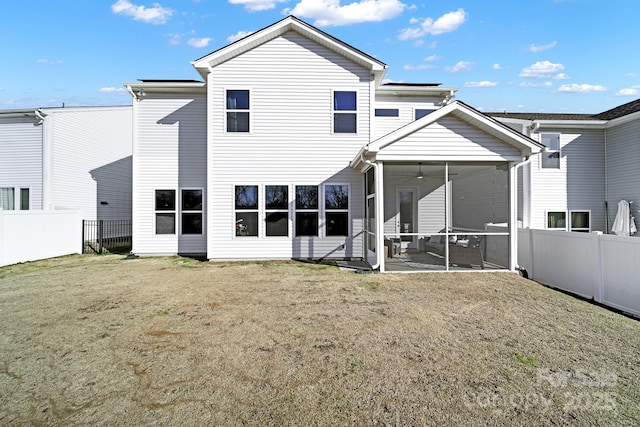 rear view of house featuring a yard, ceiling fan, a patio, and a sunroom