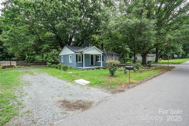 view of front of property featuring covered porch and a front lawn