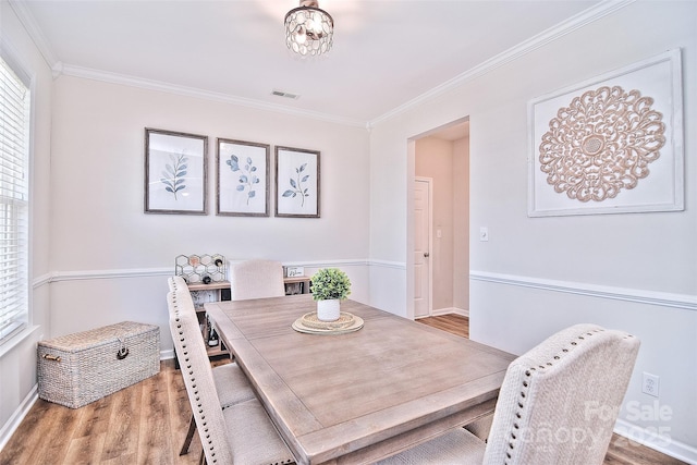 dining room featuring ornamental molding and hardwood / wood-style floors