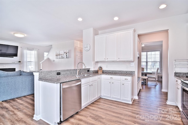 kitchen featuring sink, stainless steel dishwasher, kitchen peninsula, and white cabinets