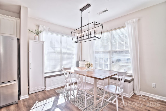 dining room with dark hardwood / wood-style floors, a wealth of natural light, and a notable chandelier