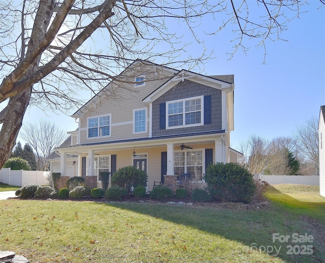 view of front of home featuring a garage, a front yard, ceiling fan, and covered porch