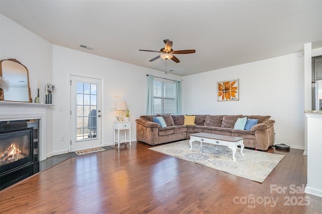 living room with dark wood-type flooring and ceiling fan