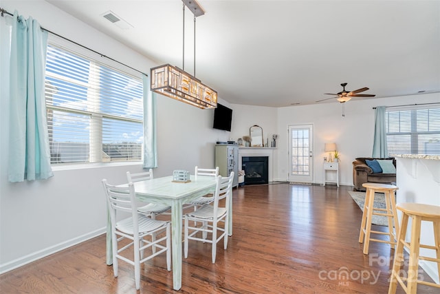 dining room featuring dark wood-type flooring, ceiling fan, and plenty of natural light