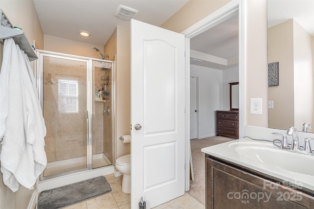 bathroom with vanity, toilet, tile patterned flooring, and a shower with door