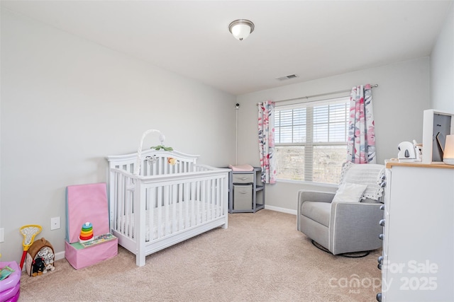 bedroom featuring a nursery area and light colored carpet