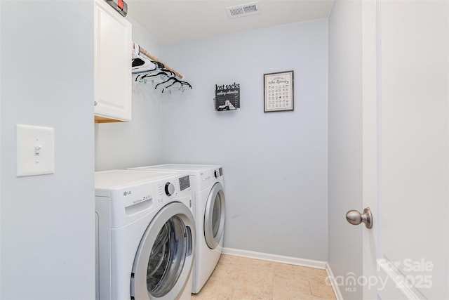 laundry room featuring cabinets, light tile patterned flooring, and washing machine and clothes dryer