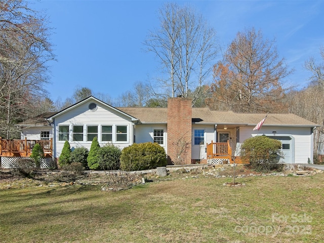 single story home with a front lawn, a chimney, an attached garage, and a deck