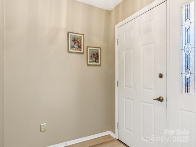 entrance foyer featuring light wood finished floors and baseboards