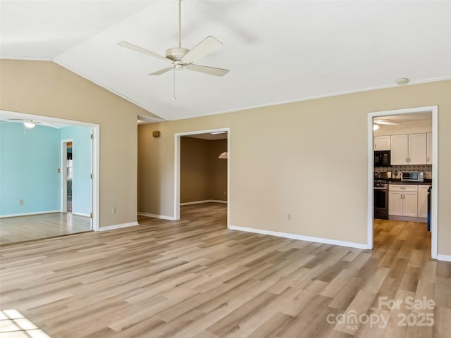 interior space with light wood-type flooring, vaulted ceiling, ceiling fan, and baseboards