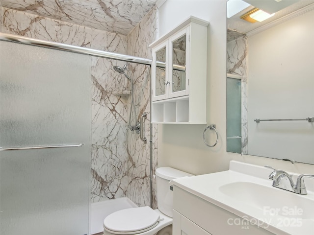 bathroom featuring a marble finish shower, vanity, and toilet