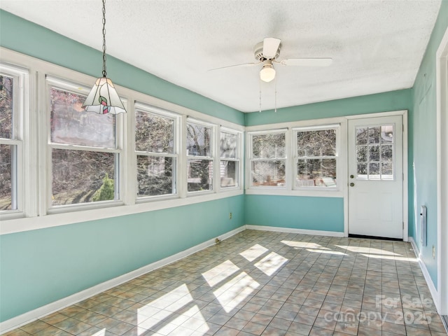 unfurnished sunroom featuring ceiling fan