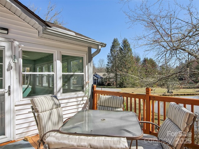 wooden deck featuring a sunroom and outdoor dining space