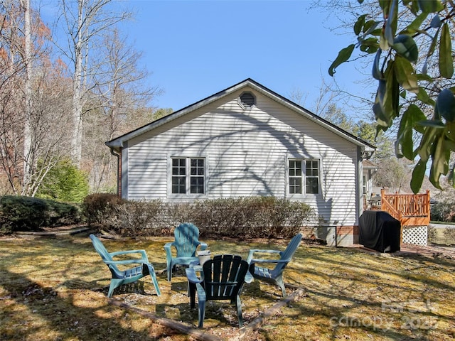 view of side of property featuring an outdoor fire pit and a wooden deck