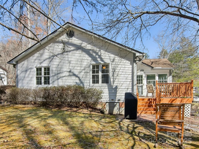 view of side of property featuring a deck and a lawn