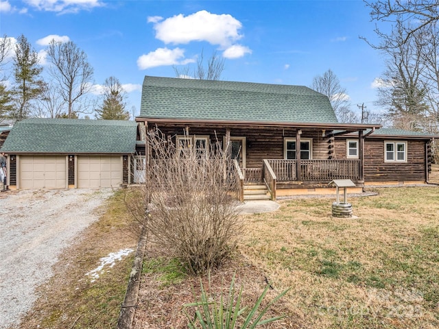 view of front of house featuring a garage, a front yard, and covered porch