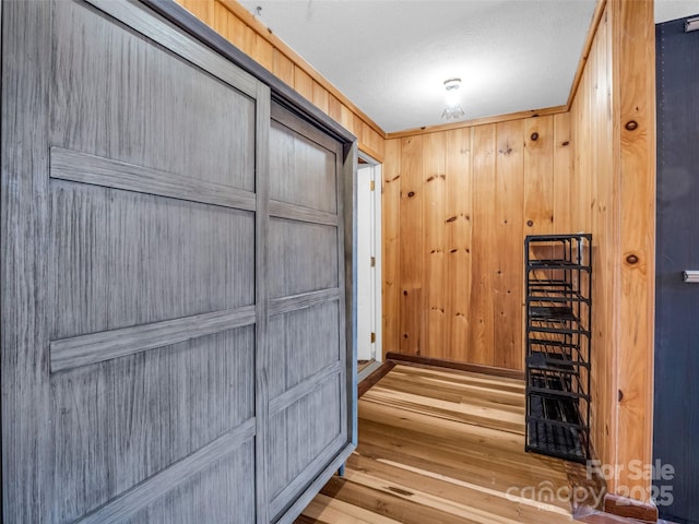 hallway featuring wood-type flooring and wood walls