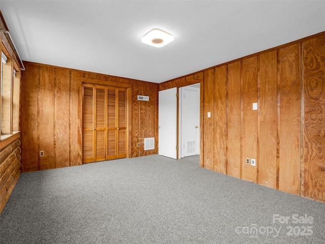 interior space featuring carpet flooring and wood walls